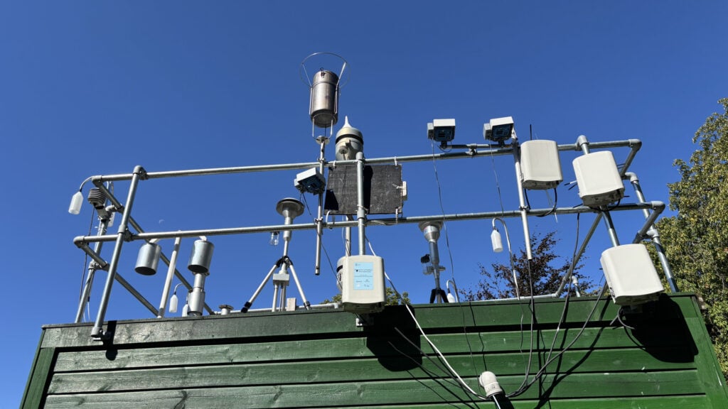 En rekke måleinstrumenter på et grønn bygning med blå himmel i bakgrunnen